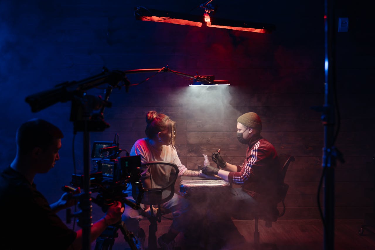 Tattoo artist creating a design in a neon-lit studio, captured with dramatic lighting.